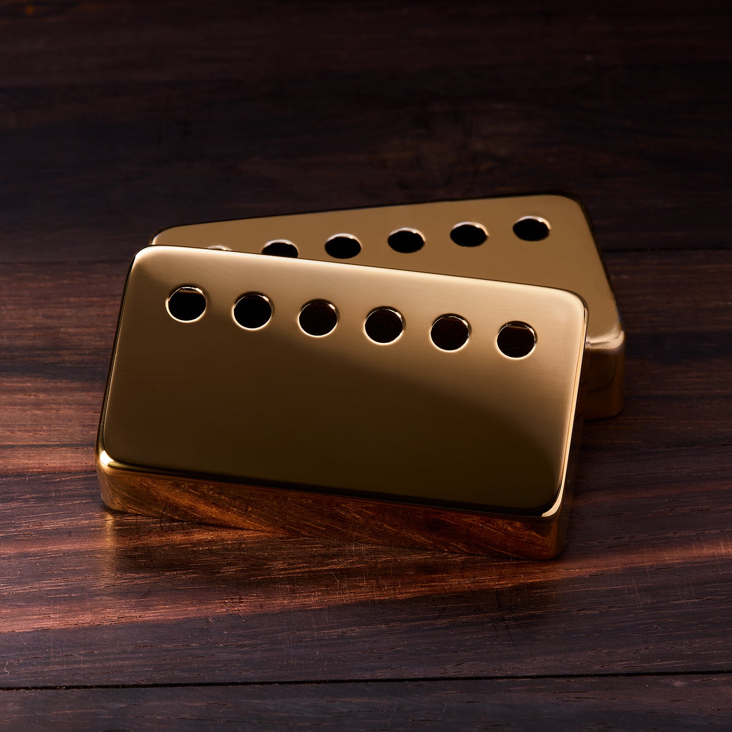 Gold guitar pickup on a wooden surface