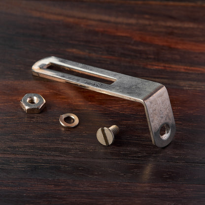 Pickguard bracket with screws on a wooden surface