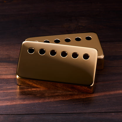 Gold guitar pickup on a wooden surface
